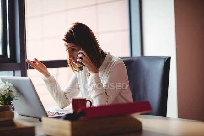 Geschäftsfrau telefoniert im Büro mit Handy — Stockfoto