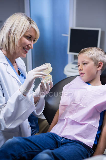 Dentist showing mouth model to patient at the dental clinic — Stock Photo