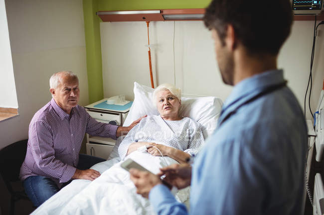 Paciente sênior interagindo com o médico no hospital — Fotografia de Stock