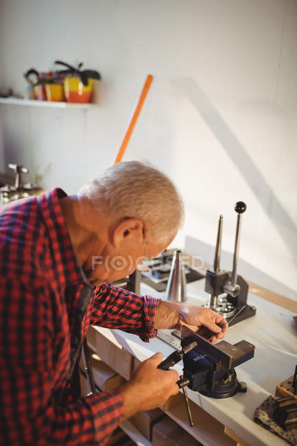 Attentive goldsmith working in workshop — Stock Photo