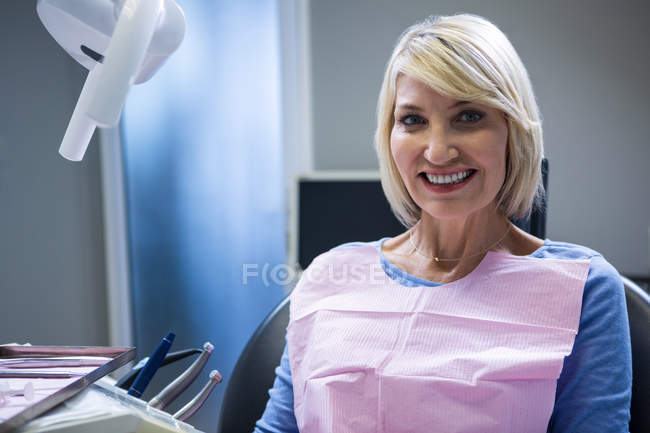Patient souriant assis sur la chaise du dentiste à la clinique — Photo de stock
