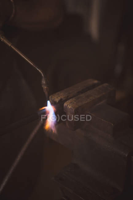 Blacksmith welding a iron rod in workshop — Stock Photo