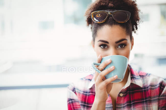 Retrato de cerca de la mujer tomando café en el restaurante - foto de stock