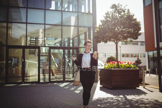 Jeune femme d'affaires marchant dans la rue — Photo de stock