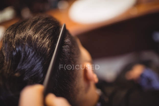 Uomo ottenere i capelli tagliati in negozio di barbiere — Foto stock