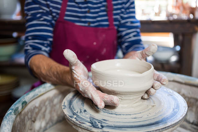 Seção média de oleiro fazendo pote na oficina de cerâmica — Fotografia de Stock