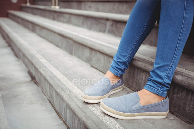 Нижняя часть женщины сидит на ступеньках — стоковое фото