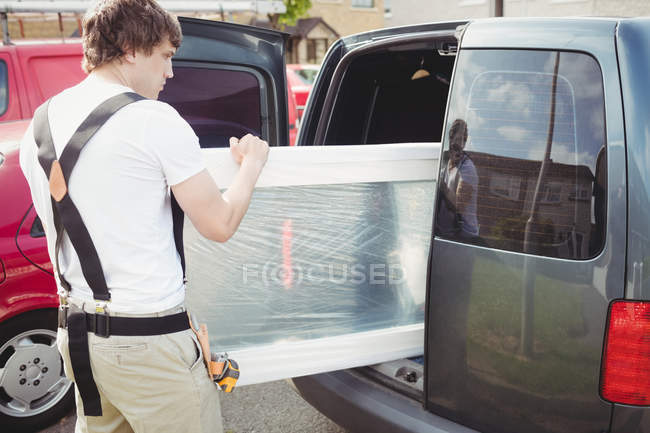 Carpintero sacando la puerta del coche - foto de stock