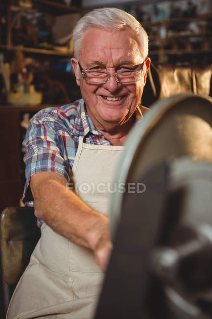 Портрет улыбающегося сапожника, работающего в мастерской — стоковое фото