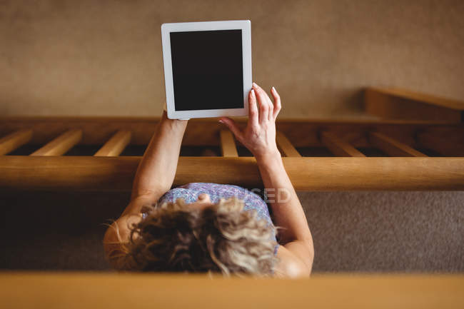 Vista ad alto angolo di Donna che tiene tablet digitale in biblioteca — Foto stock