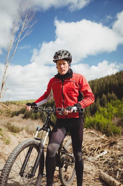 Front view of biker with bicycle at mountain against sky — Stock Photo