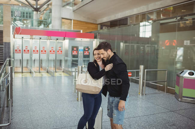 Пара обіймає один одного в аеропорту — стокове фото