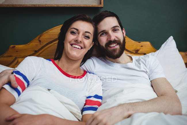 Портрет подружжя разом лежачи на ліжку в спальні — стокове фото