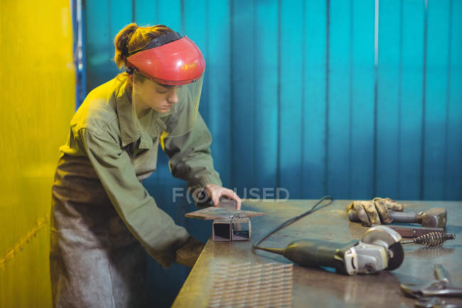 Soldador fêmea usando ferramenta na oficina — Fotografia de Stock