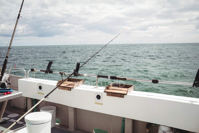 Fishing rods on fishing boat at sea — Stock Photo