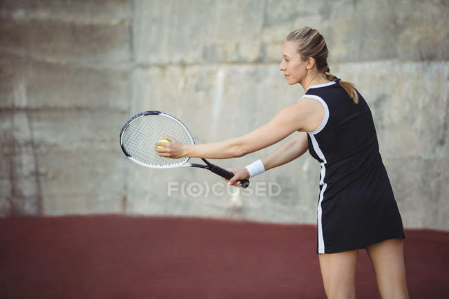 Frau mit Tennisschläger zum Servieren vor Sportgericht bereit — Stockfoto
