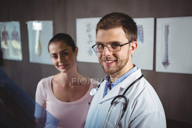 Retrato de fisioterapeuta y paciente femenina en clínica - foto de stock