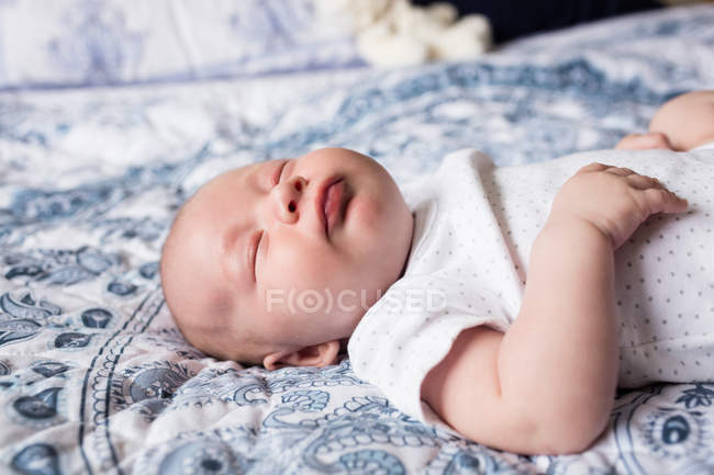 Bambino che dorme con manichino in bocca sul letto a casa — Foto stock