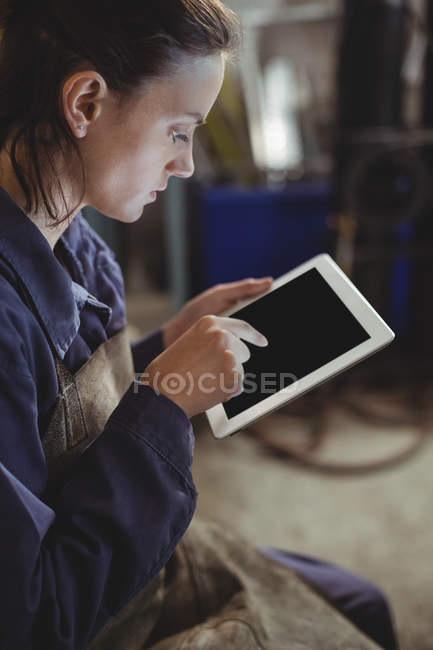 Soudeuse utilisant une tablette numérique en atelier — Photo de stock