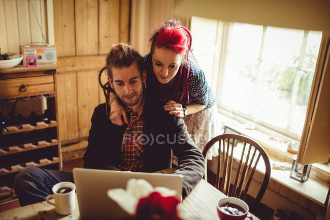 Умная пара с ноутбуком дома — стоковое фото