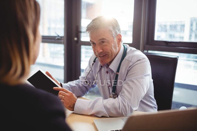 Médecin discutant avec le patient sur tablette numérique à l'hôpital — Photo de stock
