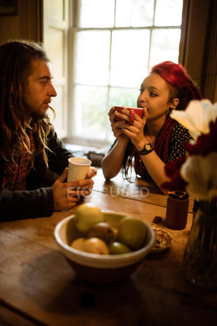 Пара беседующих за столом за чашечкой кофе — стоковое фото