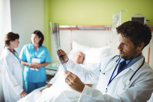 Doctor revisando informe de rayos X en el hospital - foto de stock