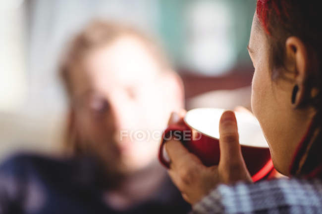Close-up of woman drinking coffee by man at home — Stock Photo