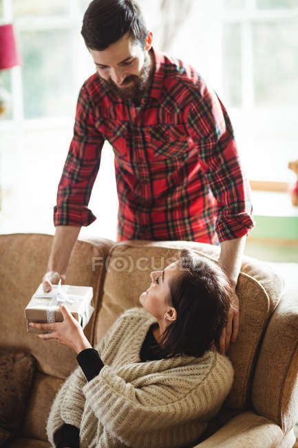 Uomo donna sorprendente con regalo in soggiorno a casa — Foto stock