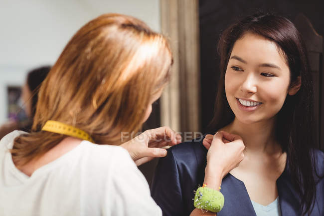 Stilista di moda misura le spalle della donna in studio — Foto stock