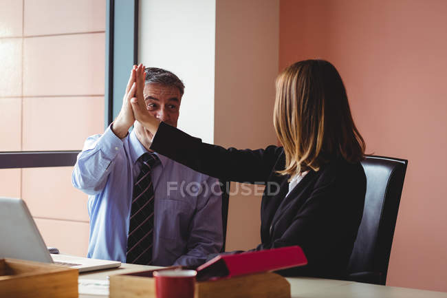 Homme d'affaires et femme d'affaires donnant haute cinq dans le bureau — Photo de stock