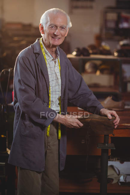 Porträt des Schuhmachers, der in der Werkstatt einen Schuh repariert — Stockfoto