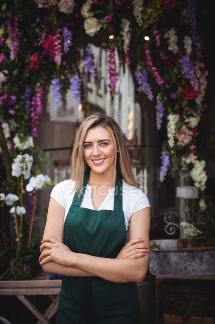 Portrait of female florist with arms crossed at her flower shop — Stock Photo