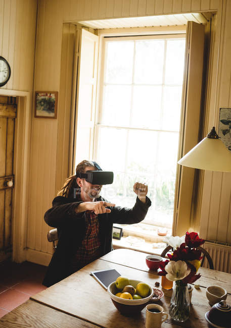 Hipster desfrutando ao usar simulador de realidade virtual em casa — Fotografia de Stock