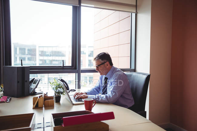 Uomo d'affari che lavora su laptop in ufficio — Foto stock