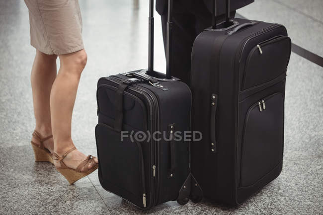 Sección baja de gente de negocios de pie con equipaje en la terminal del aeropuerto — Stock Photo
