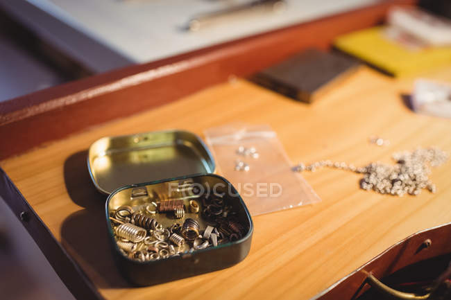Scatola portautensili aperta con molle metalliche sul banco da lavoro in officina — Foto stock