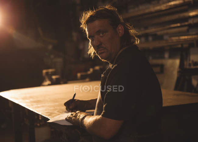 Retrato de ferreiro preparando notas na oficina — Fotografia de Stock