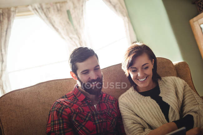 Пара с помощью цифрового планшета в гостиной на дому — стоковое фото