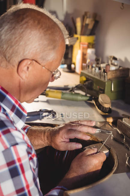 Attentive goldsmith working in workshop — Stock Photo