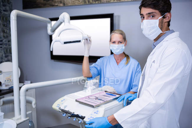 Dentiste et assistante dentaire travaillant ensemble à la clinique dentaire — Photo de stock
