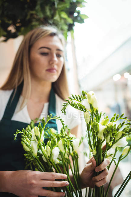 Жіночий флорист організовує квіти в квітковому магазині — стокове фото