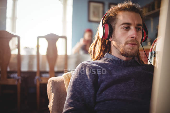 Хипстер слушает музыку, расслабляясь дома — стоковое фото