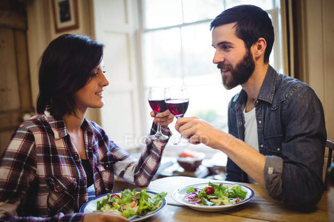 Paar stößt zu Hause auf Gläser Wein an — Stockfoto