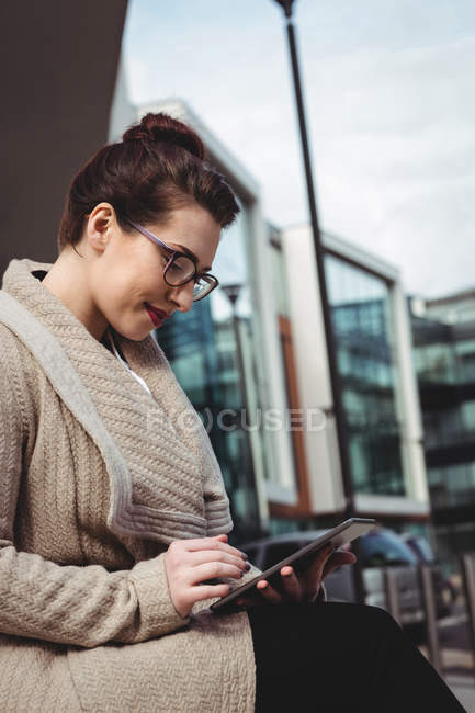 Молода жінка, використовуючи цифровий планшетний проти Сучасна будівля — стокове фото