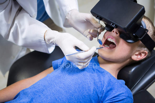 Хлопчик використовує гарнітуру віртуальної реальності під час відвідування стоматологічної клініки — стокове фото