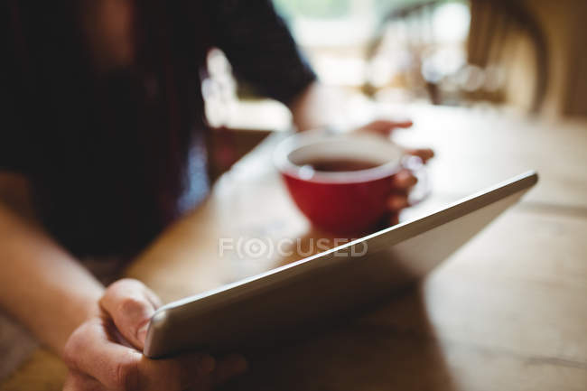 Midsection of woman using digital tablet at home — Stock Photo