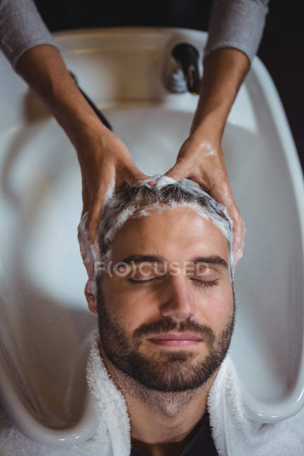 Hombre lavándose el pelo en el salón - foto de stock