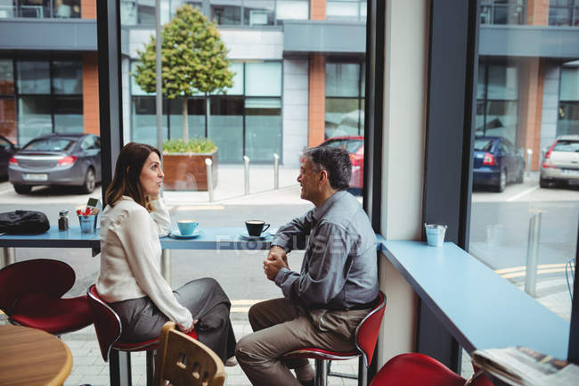 Man and woman having conversation in cafeteria — Stock Photo