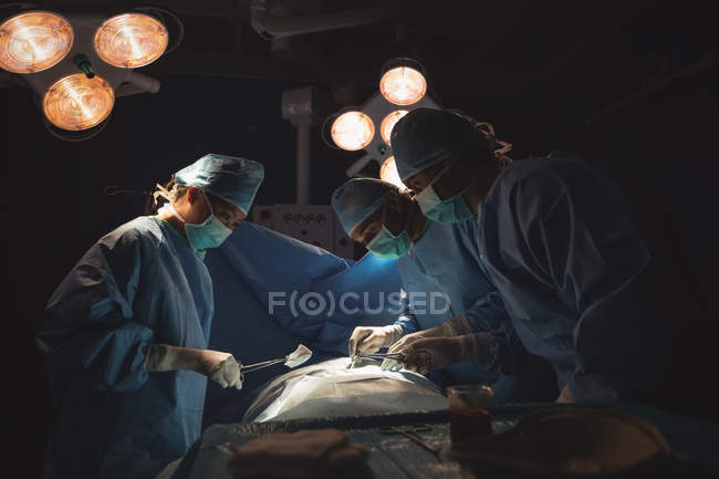 Команда хирургов, выполняющих операции в операционной в больнице — стоковое фото